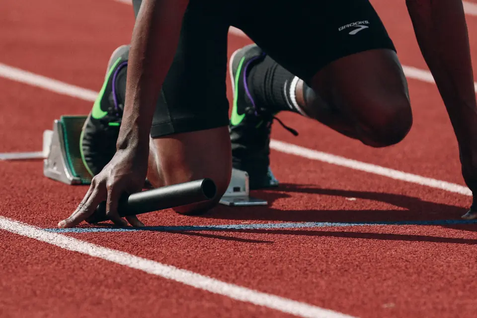 Atleta em posição de largada em uma pista de atletismo